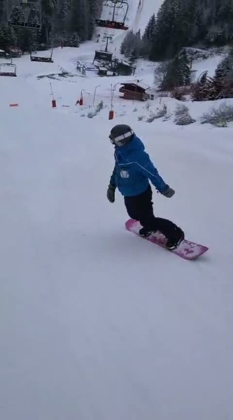 Un snowboardeur en tenue bleue travaille son virage